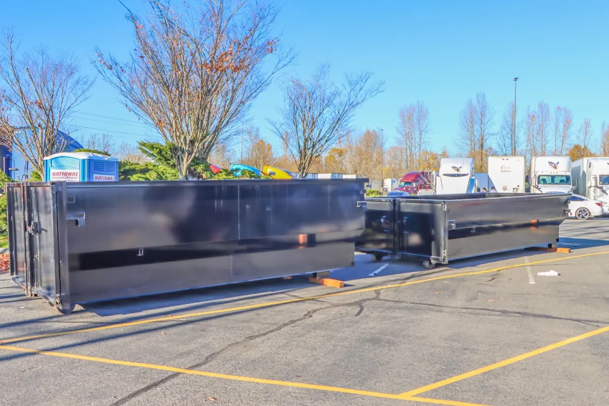 Professional dumpster rental service with roll-off container on residential driveway in Westwood